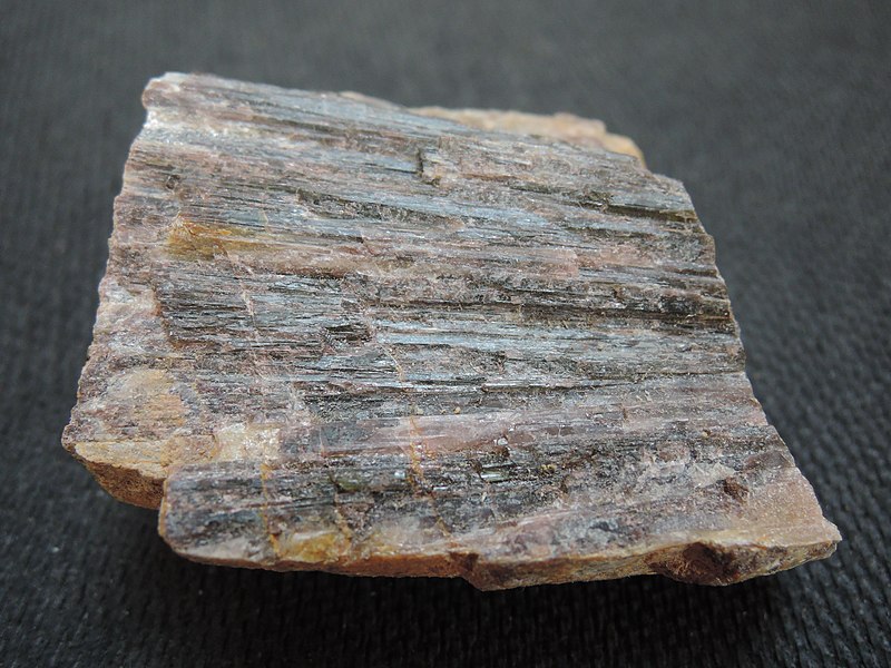A orange-gray crystal of andalusite, opaque and with long columns